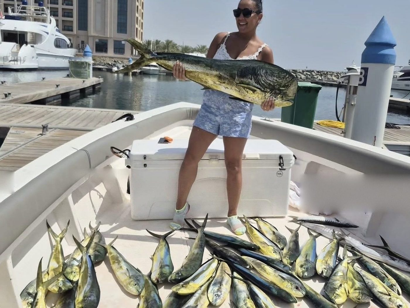 A guest holding a large dorado on a fishing boat at Fujairah marina
