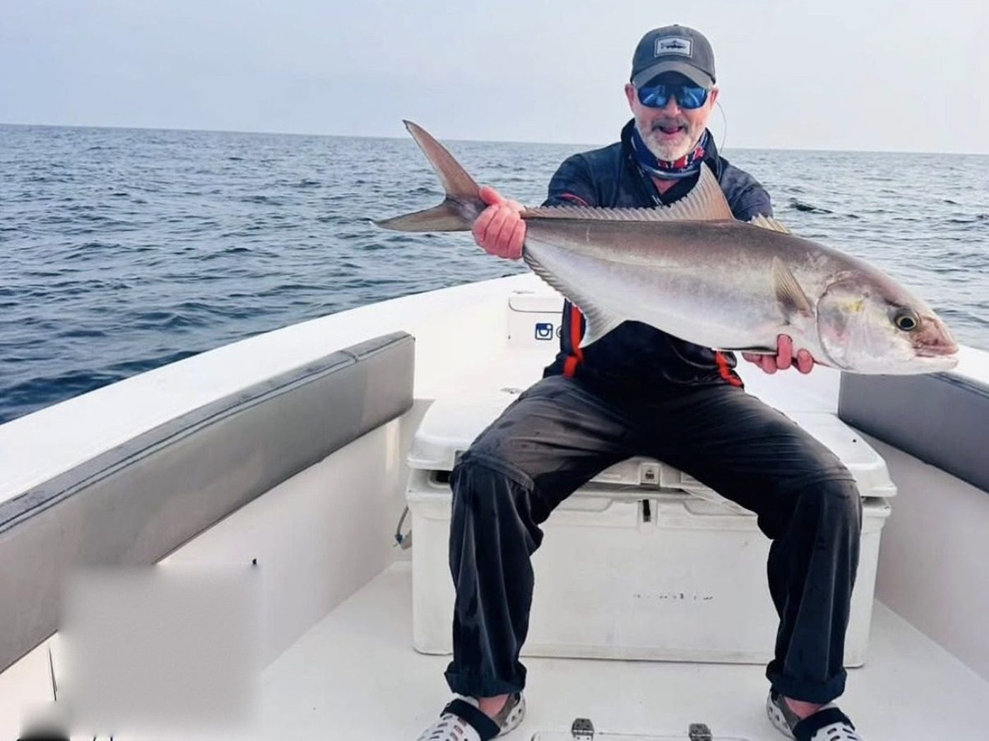 A guest holding a large silver fish caught off Fujairah