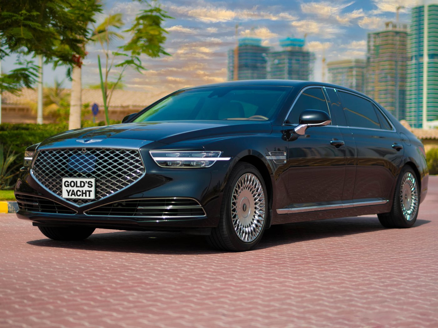 A black Genesis G90 sedan used for Gold's Yacht premium transfers, Dubai skyline behind