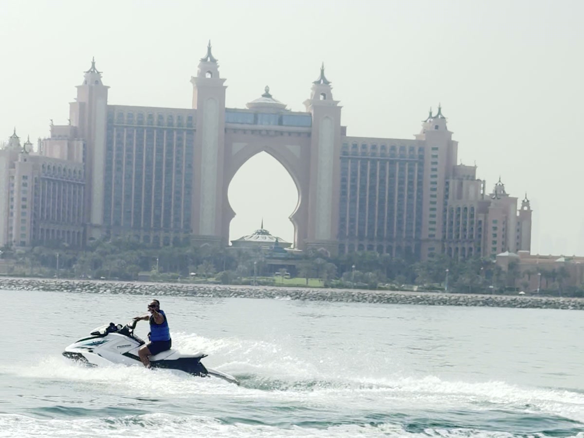 Гидроцикл на воде, за ним арка отеля Atlantis The Palm